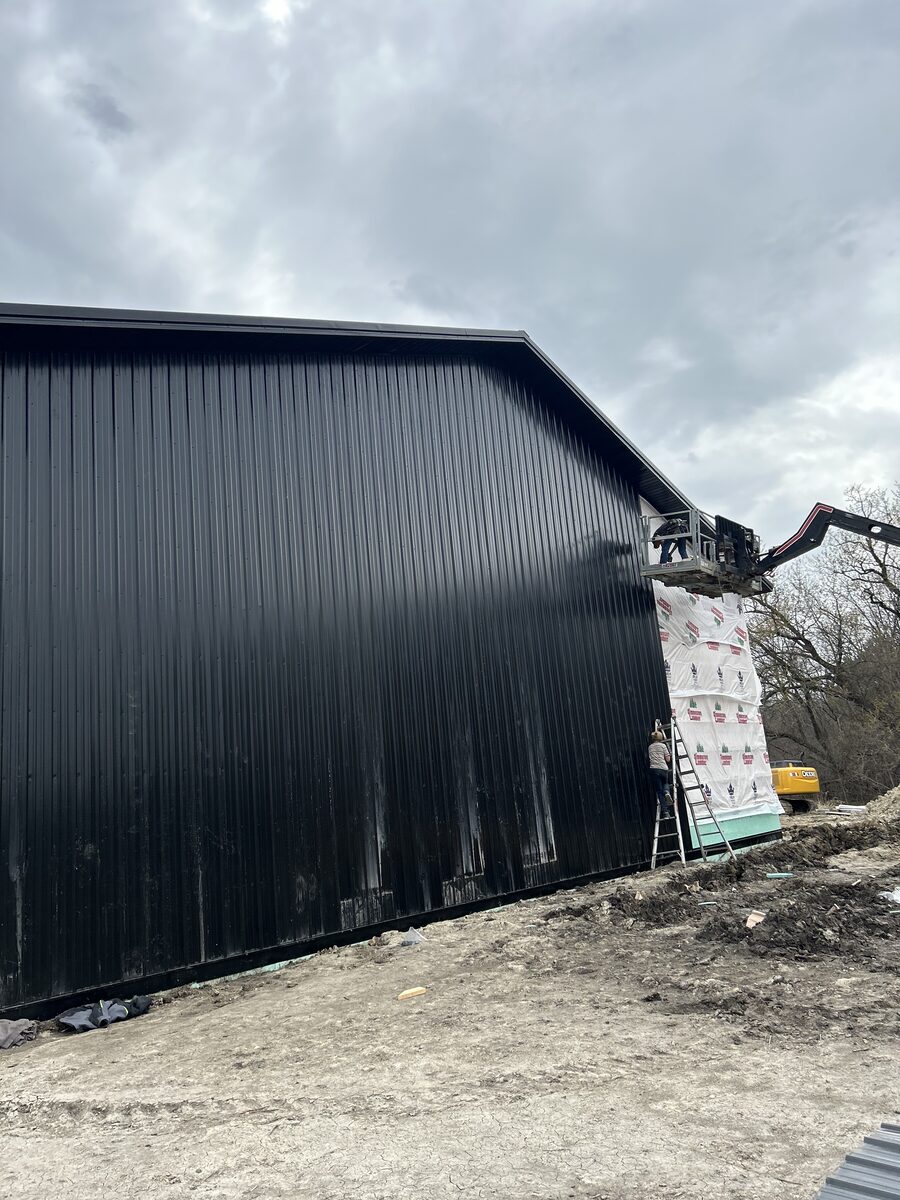 Black metal siding installation on a building by Zerkle Construction